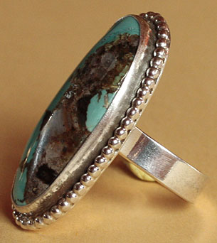 A big american turquoise with brown matrix is serrated on this american south western Artist hand made ring