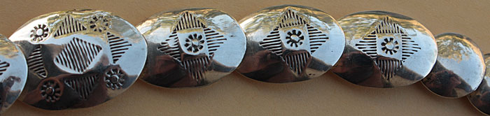 Les grosses perles creuses artisanales de ce collier Navajo sont en argent et elles sont ornées de motifs ethniques amérindiens