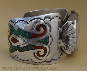 Bijou Navajo, ce bracelet montre incrusté de turquoise et corail est orné de symboles Soleil, Mâchoires de serpent